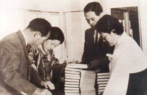 Reverend and Mrs. Moon looking at the first printing of Wolli Kangron (Divine Principle)