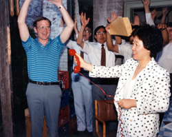 Mrs. Moon holding the telephone so that Reverend Moon, in prison, can hear the members cheering him